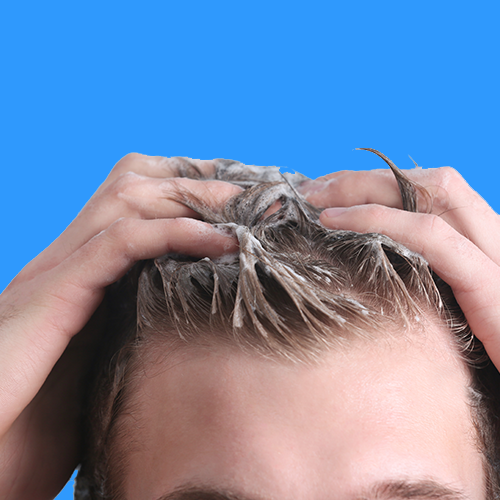 Man rubbing in pre-shampoo conditioner to his hair 